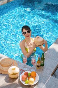三亚三亚海棠湾JW万豪度假酒店(西班牙风情+迷你吧）的坐在游泳池里喝一杯的女人