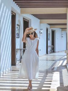 三亚三亚海棠湾JW万豪度假酒店(西班牙风情+迷你吧）的穿着白色衣服和帽子的女人