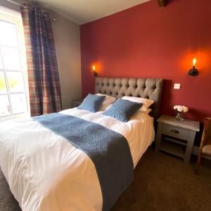 AcleThe Kings Head Inn, home of The Acle Steak的卧室配有白色的床铺和红色的墙壁