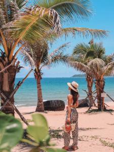 三亚三亚海棠湾JW万豪度假酒店(西班牙风情+迷你吧）的站在棕榈树海滩上的女人