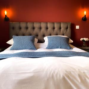 AcleThe Kings Head Inn, home of The Acle Steak的卧室配有带蓝色枕头的大型白色床