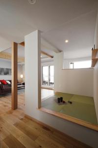 富良野AKATSUKI的客厅拥有白色的墙壁和绿色的地毯。