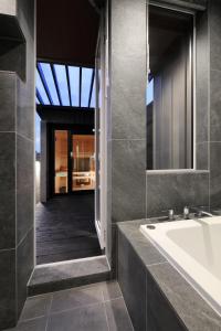 富良野AKATSUKI的带浴缸、水槽和镜子的浴室