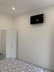 圣焦万尼泰亚蒂诺La Bussola Airport Affitta Camere的卧室配有一张床,墙上配有电视。