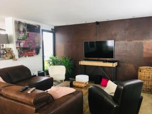 拉罗谢尔Bubble House的客厅配有皮革家具和平面电视