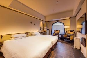 熊本日航熊本酒店的酒店客房,配有两张床和椅子