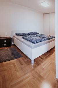 萨格勒布Z'Argette Apartment - Free Parking @ Zagrebacka C.的铺有木地板的客房内的一张白色床