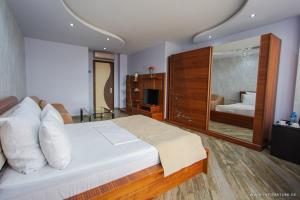 巴统Hotel Nica的一间卧室配有一张大床和大镜子