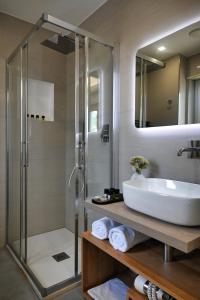 布罗洛El Concept Room的一间带玻璃淋浴和水槽的浴室