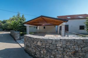 LovrećCountry House Dumančić with nice garden and hot tub的房屋内有木屋顶的石墙