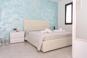 乌真托Il Sorriso B&B的卧室配有白色的床和蓝色的墙壁