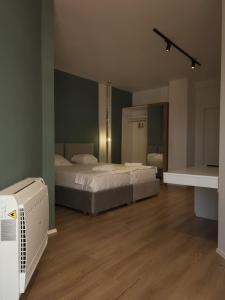 地拉那Capital Suites Center的客房设有两张床和风扇。