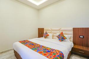 勒克瑙FabHotel DDS的卧室配有一张带彩色枕头的大型白色床。