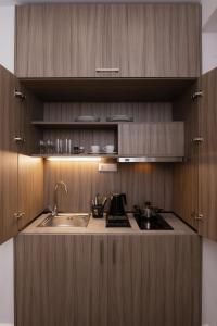 塞萨洛尼基ELITE APARTMENTS的一个带木制橱柜和水槽的厨房