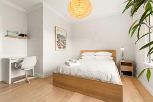 悉尼Sunlit 2BR Coastal Charm Bondi Beach Beach View的一间卧室配有一张带桌子和椅子的床