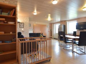 布尔格-罗伊兰德Comfy Holiday Home in Burg Reuland with Sauna Terrace BBQ的用餐室配有婴儿床和桌椅