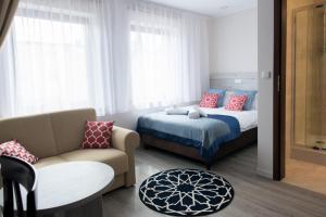 切霍齐内克安达卢西亚SPA休闲住宿加早餐旅馆的一间卧室配有一张床、一张沙发和一把椅子