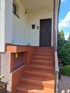 SierpcApartament Matejki的一座带橙色楼梯的房屋的前门