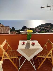 内比达Villa Mariuccia的阳台的桌子、两把椅子和花瓶