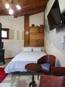 吉诺卡斯特Guest House Seferi Ξενωνας Σεφερη的一间卧室配有一张床、一张桌子和一台电视。