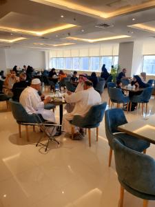 科威特Dolphin Continental Hotel的一群坐在餐厅桌子上的人