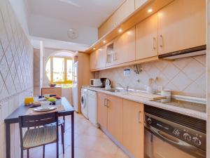 奎特里拉AL - Apartamento Quinta do Romão的厨房配有木制橱柜、桌子和水槽。