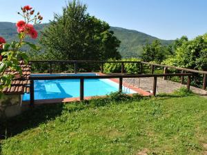 圣马尔切洛皮斯托耶塞Lovely Holiday Home with private pool的田野上的游泳池,有围栏和鲜花