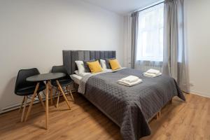 波兹南Apartamenty Słowackiego 16的一间卧室配有一张床、两把椅子和一个窗户