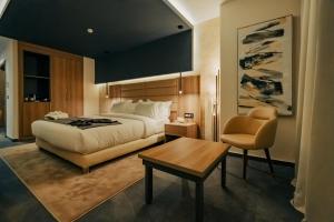 阿尔及尔AD HOTEL HYDRA的卧室配有1张床、1张桌子和1把椅子