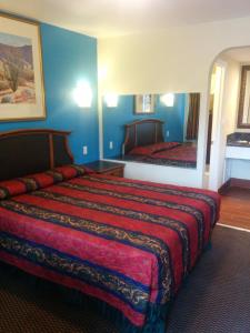 圣贝纳迪诺阳光汽车旅馆的配有一张大床和镜子的酒店客房