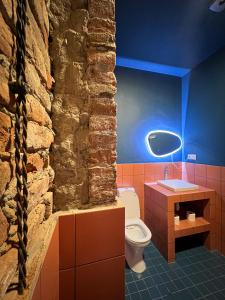 库塔伊西Black Tomato Hostel Kutaisi的一间带卫生间和石墙的浴室