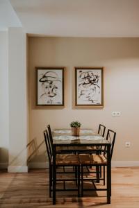 托雷德尔马尔Apartamentos Poniente - Mares的餐桌、椅子和墙上的绘画
