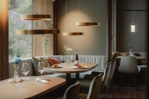 采尔马特欧洲酒店和温泉中心的餐厅设有2张桌子和椅子以及窗户。