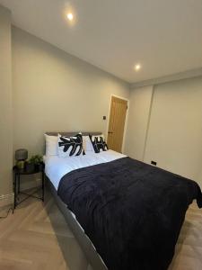 伦敦Luxury 2 bed 1 bath in Central London by Graceful Apartments的一间卧室配有一张大床、黑色毯子和枕头