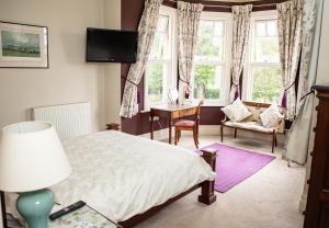 威勒尔Mere Brook House的卧室配有一张床、一张书桌和窗户。