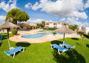 卡拉罗曼蒂卡Apartamentos Sol Romántica by DOT Suites的一个带两把草坪椅和遮阳伞的游泳池