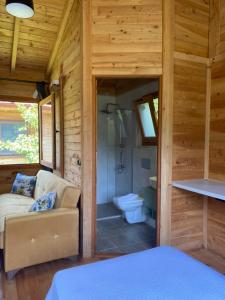 费特希耶İnlice Ünzile Bungalow İNLİCE KAMP的一间小屋内配有沙发和淋浴的房间