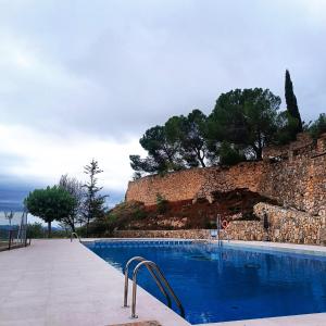 La Morera de MontsantHotel Balcó del Priorat的石头墙前的游泳池