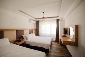 格克切达镇Estia Hotel的酒店客房设有两张床和电视。