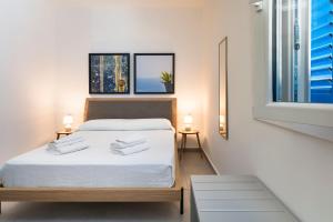 兰佩杜萨DipintodiBlu Charming House的一间卧室配有一张带白色床单的床和一扇窗户。