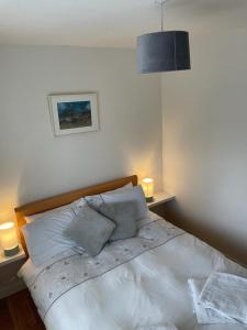 戈尔韦Beautiful one bedroom Apartment In Galway City的一间卧室配有一张带两盏灯的大型白色床。