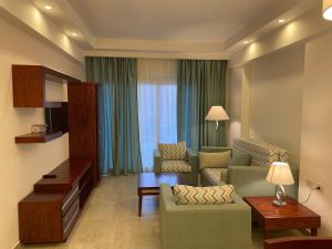 阿布达巴Oyster Bay Marsa Alam (unit I6-13)的客厅配有沙发、椅子和电视