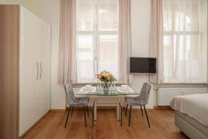 巴登-巴登Comfort Apart Baden-Baden的一间带桌椅和一张床的用餐室