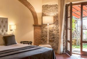 宛图里那Calidario Terme Etrusche的一间卧室设有一张床和石墙