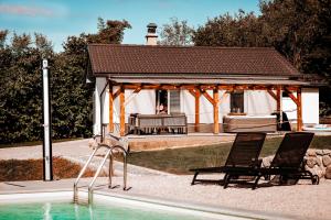 ŠentjernejHoliday House Sunset Spa的游泳池旁带两把椅子的凉亭