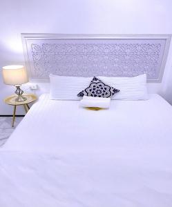 大城Zleepinezz Hostel的白色卧室配有白色的床和灯