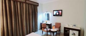 迪拜Signature Inn Hotel - Free Parking的配有桌椅和镜子的客房