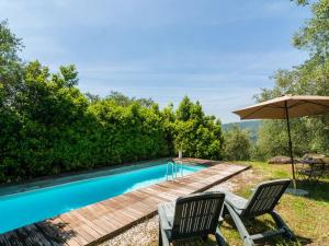 UzzanoIdyllic Holiday Home in Pescia with Swimming Pool的一个带两把椅子和遮阳伞的游泳池