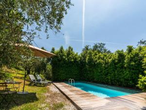 UzzanoIdyllic Holiday Home in Pescia with Swimming Pool的一个带木甲板的庭院内的游泳池