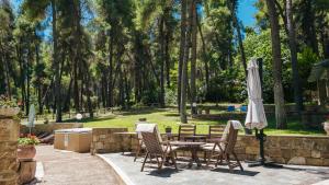 撒尼海滩Sani Cape Shared Pool Villas的庭院配有桌椅和遮阳伞。